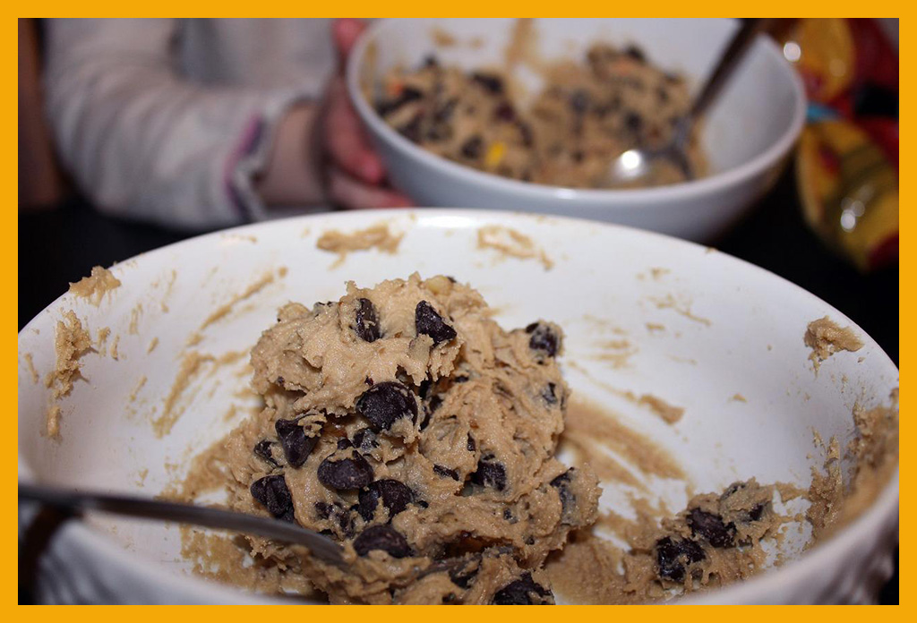 Photo of raw chocolate-chip cookie dough in a large white bowl